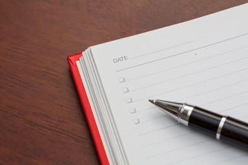 Naklejka premium Conceptual,notebook on a wooden table. open diary and pen to record