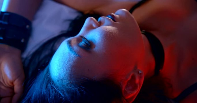 brunette lady with dramatic makeup in sexual clothes on bed