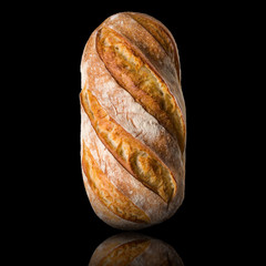 Fresh baked rye bread with reflection isolated on a black background