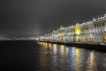 State Hermitage Museum in St. Petersburg. Night shooting. View of the Neva River, Palace Embankment, Trinity Bridge. Beautiful panorama with night lights. Reflection of holiday lights in the river. Ch