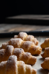 baked bagels sprinkled with sugar lie on a baking sheet with parchment