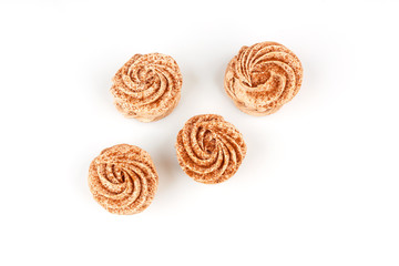 Four marshmallows, sprinkled with cinnamon and chocolate, lie on a white background. Top view isolated on white background.