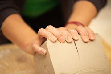 hands of a woman working on pottery