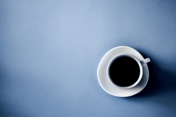 Classic blue color background with a cup of coffee flat lay, copy space. Classic blue 2020. Gradient color palette.