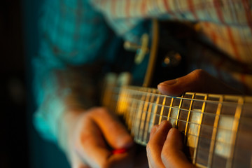 Man's hands play the guitar, close up