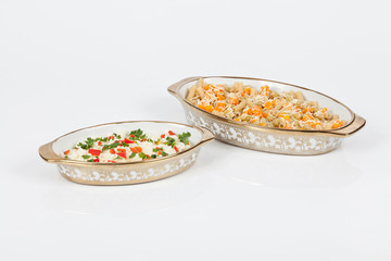 Glass oven tray on white background with food.