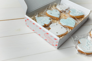 Christmas gingerbread cookies. Hearts and sweaters shapes. Winter sweets on white wooden background. Place for text.