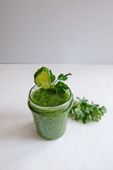 Green cocktail of spinach, lemon, cucumber and parsley on a light background. The concept of healthy nutrition, detox, green, diet, vegan, keto, fit. Vertical. Copy space