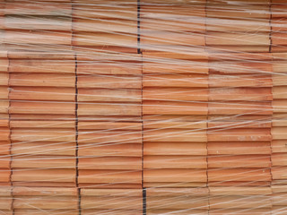 Orange bricks wrapped in plastic wrap. Construction material.