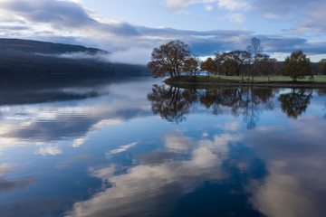Breathtaking vibrant aerial drone landscape images over Coniston Water at sunrise on beautiful Autumn Fall morning