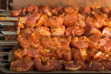 Raw meat on skewers. Meat slices prepare on fire.