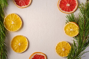 Fototapeta na wymiar Creative holiday Christmas New Year food fruit texture with dried grapefruit, orange and lemon with branch of fir tree, top view, empty white background copy space