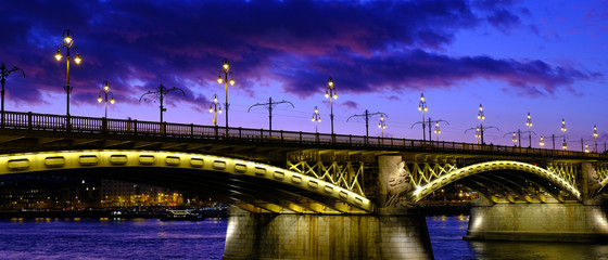 Fototapeta na wymiar Illuminated Margaret or Margit bridge in Budapest, Hungary at night. Wide panoramic view.