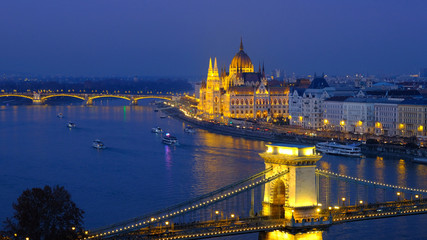Naklejka na ściany i meble Budapest city at blue hour with illuminated Hungarian Parliament and Chain Bridge over Danube River. Panoramic view.