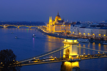 Budapest city panorama at night with illuminated Hungarian Parliament building on Danube River and Chain Bridge.
