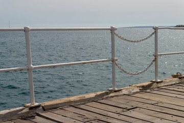 Obraz premium Metal fence at the wooden old pier