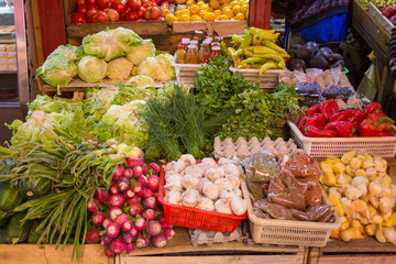 Colorful display of food, fresh vegetables and spices, at the locally produced market Caleta Angelmo, in Puerto Montt, Chile. There are lettuce, chili, green onion, garlic, radish, etc