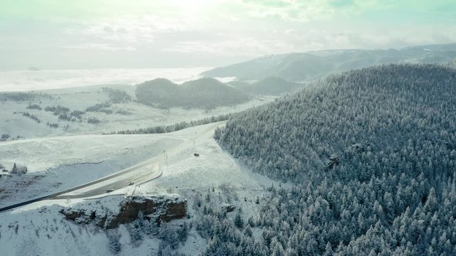 Aerial: Road passing through snowy mountains at Dead Indian Summit Overlook on Chief Joseph highway, Cody, Wyoming, USA