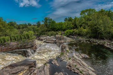 Fototapeta na wymiar Hog's Back Falls Ottawa raging river through rock canyon with calm pool of water in foreground nobody