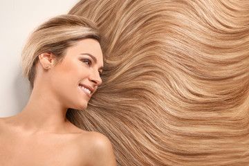 Beautiful young woman with healthy long hair on white background