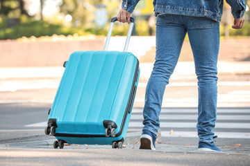 Young male tourist with luggage outdoors