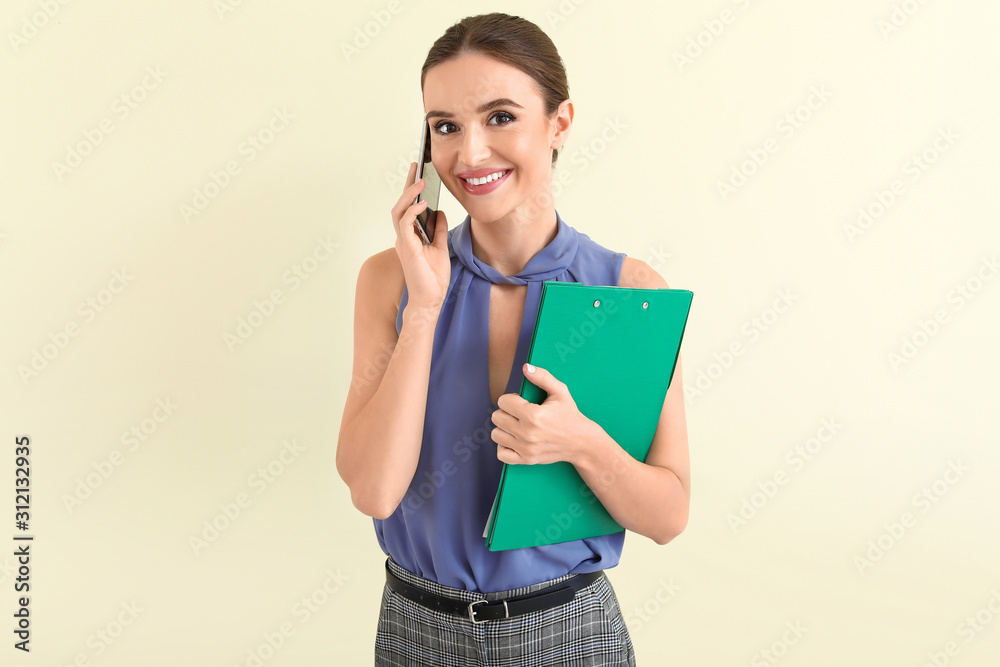 Sticker Female real estate agent talking by mobile phone on light background