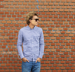 Teenager standing near a brick wall	