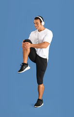Sporty African-American man training on color background
