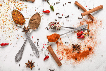 Spoons with different spices on white background