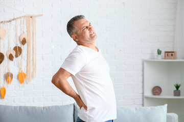 Mature man suffering from back pain at home