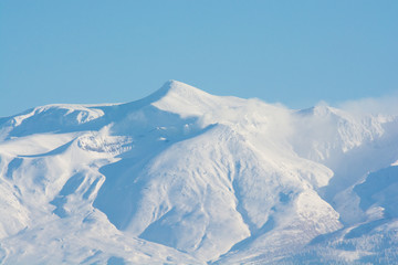 青空と雪山の山頂　十勝岳