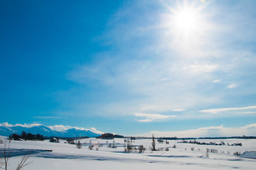 Fototapeta na wymiar 冬の丘陵地帯と太陽
