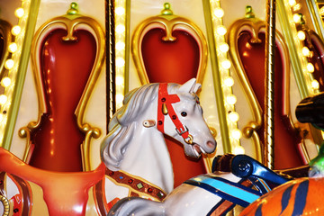 Carousel horse colorful closeup with lights, beautiful white horse