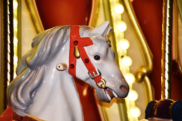 Fototapeta na wymiar Carousel horse colorful closeup with lights, beautiful white horse