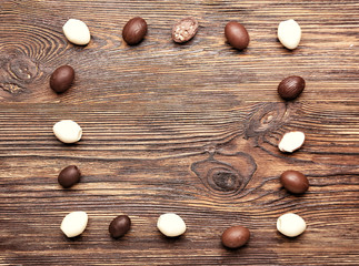 Frame made of chocolate Easter eggs on wooden background