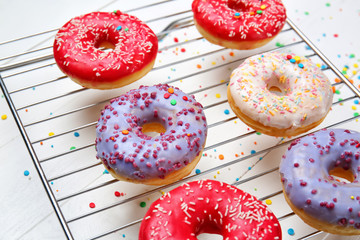 Sweet tasty donuts on white wooden background