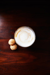 Coffee with milk in glass cup and amaretti cookies on rustic wooden background. Top view. Copy space. 
