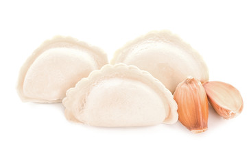 Raw dumplings with garlic on white background