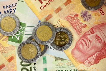 Mexican pesos bills spread randomly over a flat surface