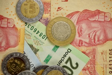 Mexican pesos bills spread randomly over a flat surface