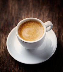 Cup of coffee on rustic wooden background. 