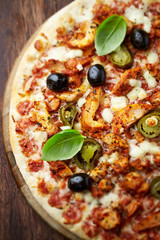 Chicken Gyro Pizza jalapeno pepper, black olives and fresh gerbs. Brown wooden background. Top view. 