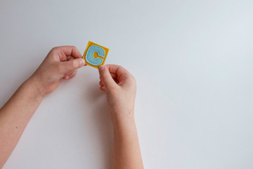 Alphabet. Letter C. Hands of the child hold letters. Learn ABC alphabet with baby.