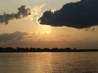 sun behind cloud river landscape