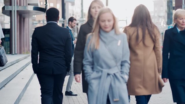 Diverse and Multicultural Office Managers and Business People Commute to Work in the Morning or from Office on a Cloudy Day on Foot. Pedestrians are Smart Casually Dressed. People Using Smartphones.