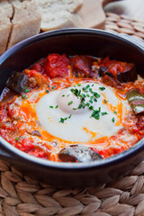 Pisto con huevo -  Spanish cuisine roasted vegetables ratatouille with poached egg.