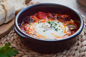 Pisto con huevo -  Spanish cuisine roasted vegetables ratatouille with poached egg.