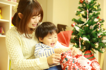 クリスマスプレゼントを開ける親子