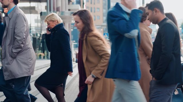 Diverse and Multicultural Office Managers and Business People Commute to Work in the Morning or from Office on a Sunny Day on Foot. Pedestrians are Smart Casually Dressed. People Using Smartphones.
