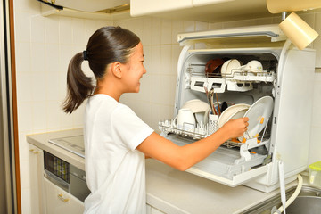 食洗器で食器を洗浄する女の子